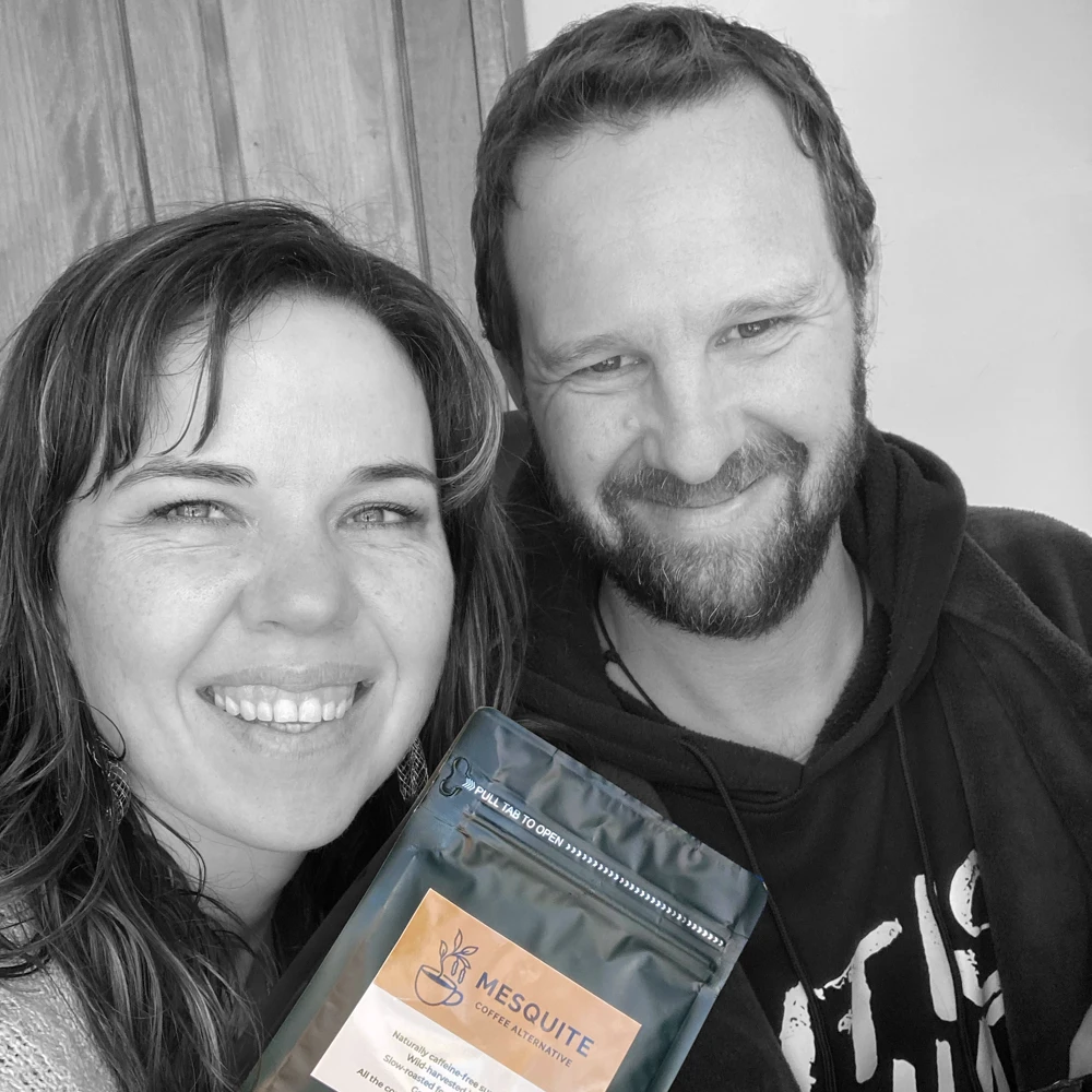 Douglas and Letitia Webber smiling together while holding a packet of Mesquite Coffee Alternative, representing the founders and their heart-centered superfood brand.