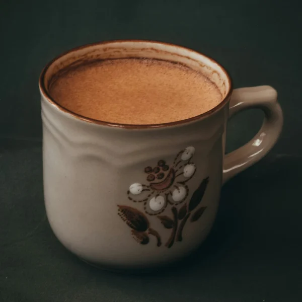 Hot chocolate drink made with premium cocoa powder in decorative ceramic mug with floral design